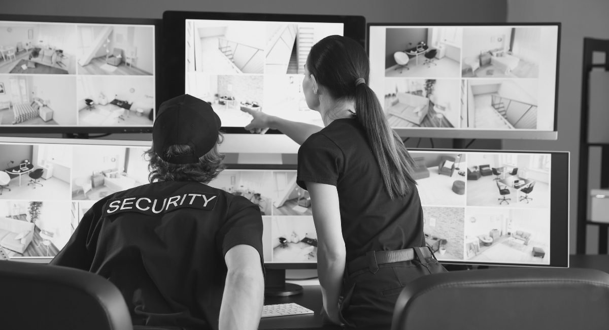 Security officers watching surveillance camera feeds illustrating the impact of surveillance on human cognition and perception.
